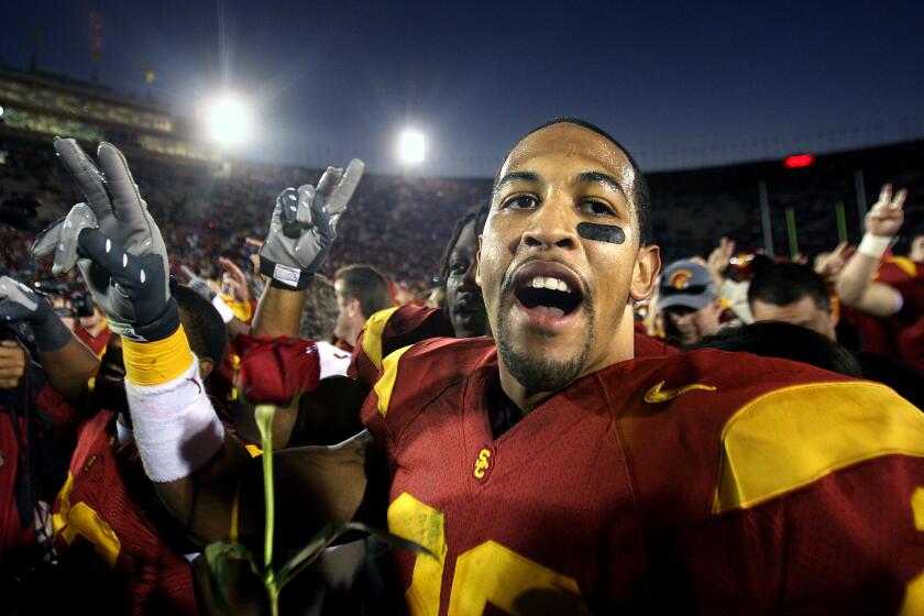 USC's Terrell Thomas celebrates with a rose after defeating UCLA at the Coliseum in 2007.