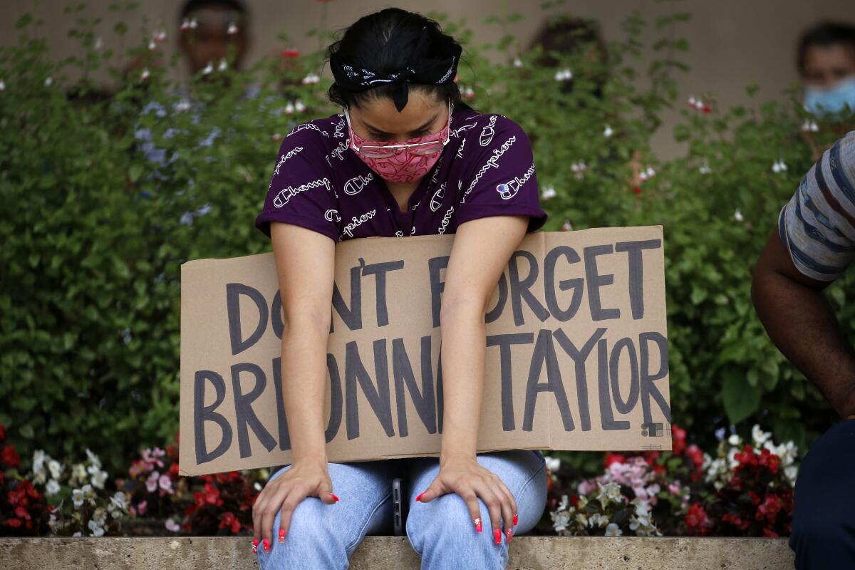 A protester holds a Breonna Taylor sign at a June rally for Black Lives Matters in Dallas.