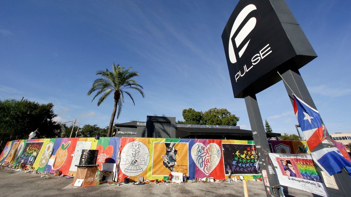 Artwork and signatures cover a fence around the Pulse nightclub in Orlando, Fla., in 2016.