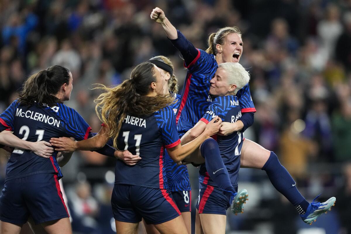 OL Reign forward Veronica Latsko jumps into the arms of Megan Rapinoe while celebrating scoring against Angel City 