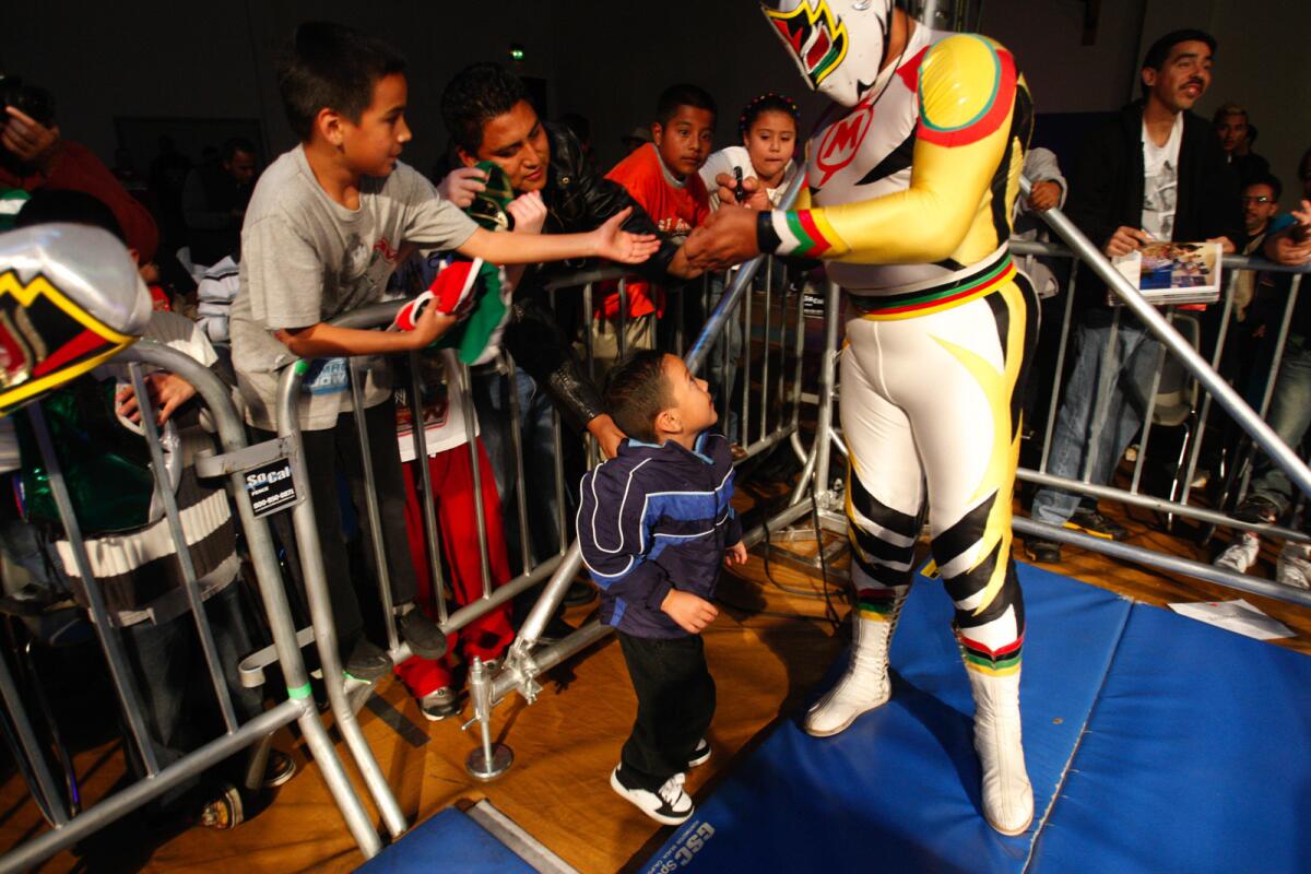 El luchador Mascara Sagrada firma autógrafos durante un evento celebrado al sur de Los Ángeles.