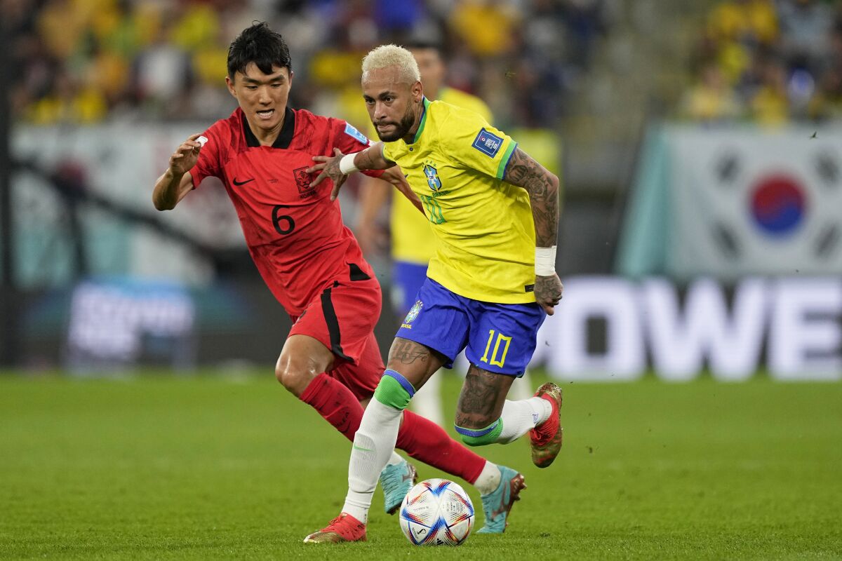 Neymar controls the ball in front of South Korea's Hwang In-beom (left) during Monday's game.