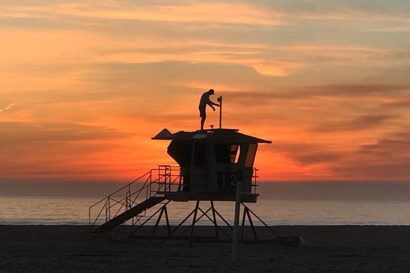 HUNTINGTON BEACH, CALIF. -- THURSDAY, JANUARY 18, 2018: With a scenic sunset view, Vitaliy Kostylov installs Wi-Fi and solar panels on lifeguard towers at Huntington State Beach in Huntington Beach Thursday, Jan. 18, 2018. (Allen J. Schaben / Los Angeles Times)