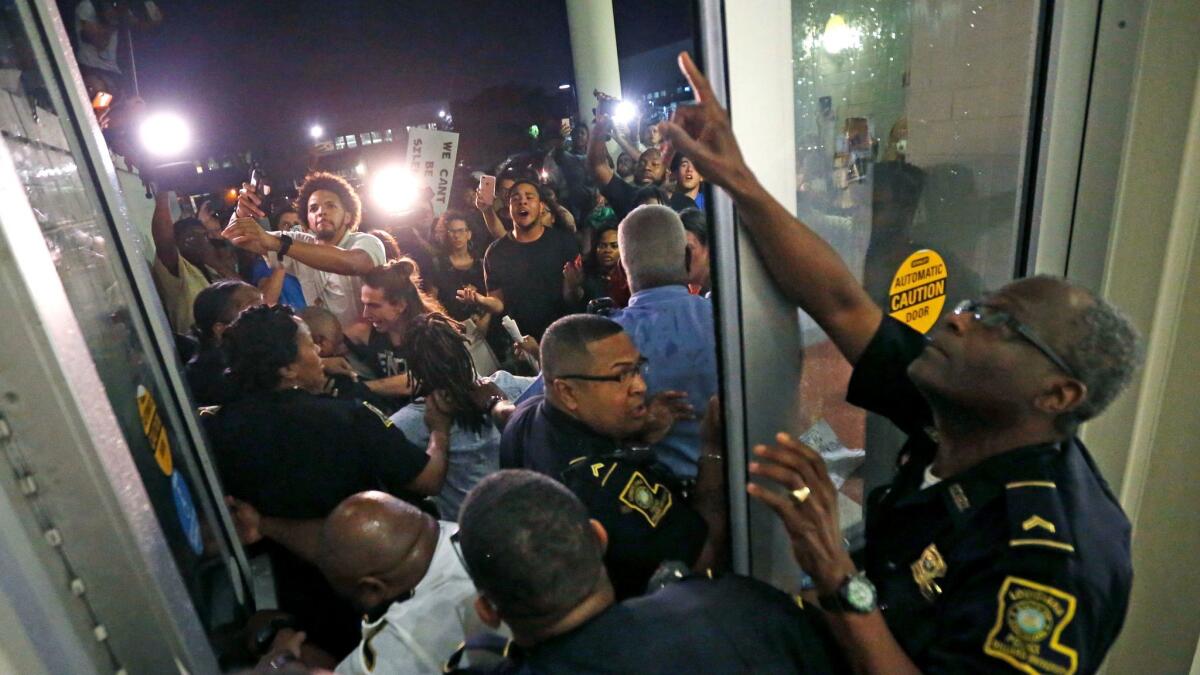 Police keep protesters from pushing through a door before a U.S. Senate debate at Dillard University on Wednesday.