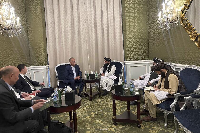 In this photo released by the Taliban Spokesman Office, Zabihullah Mujahid, the chief spokesman for the Taliban government who leads the Taliban delegation, center right, speaks with Uzbekistan Presidential Envoy to Afghanistan Ismatullah Irgashev, during a meeting in Doha, Qatar, Sunday, June 30, 2024. A Taliban delegation is attending a United Nations-led meeting in Qatar on Afghanistan after organizers said women would be excluded from the gathering. The two-day meeting is the third U.N.-sponsored gathering on the Afghan crisis. (Taliban Spokesman Office via AP)