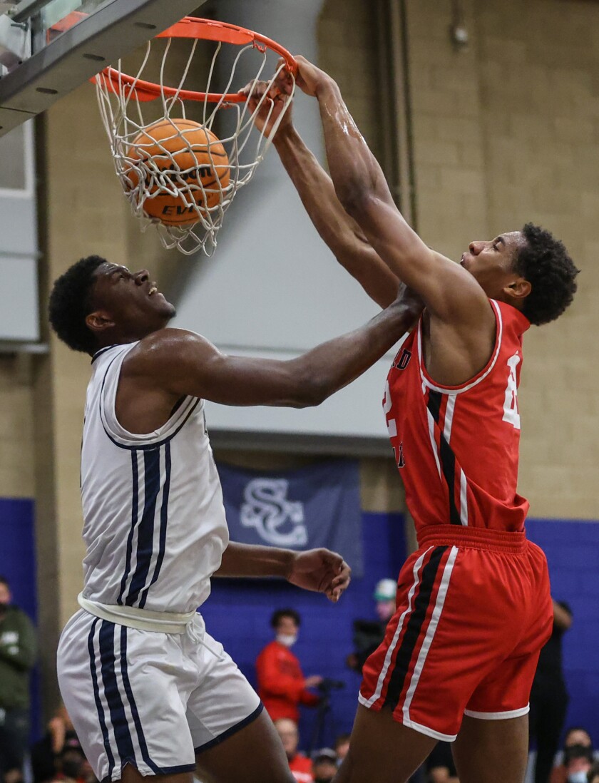 Harvard-Westlake's Landon Lewis, right, dunks over Sierra Canyon's Kijani Wright late in the game.