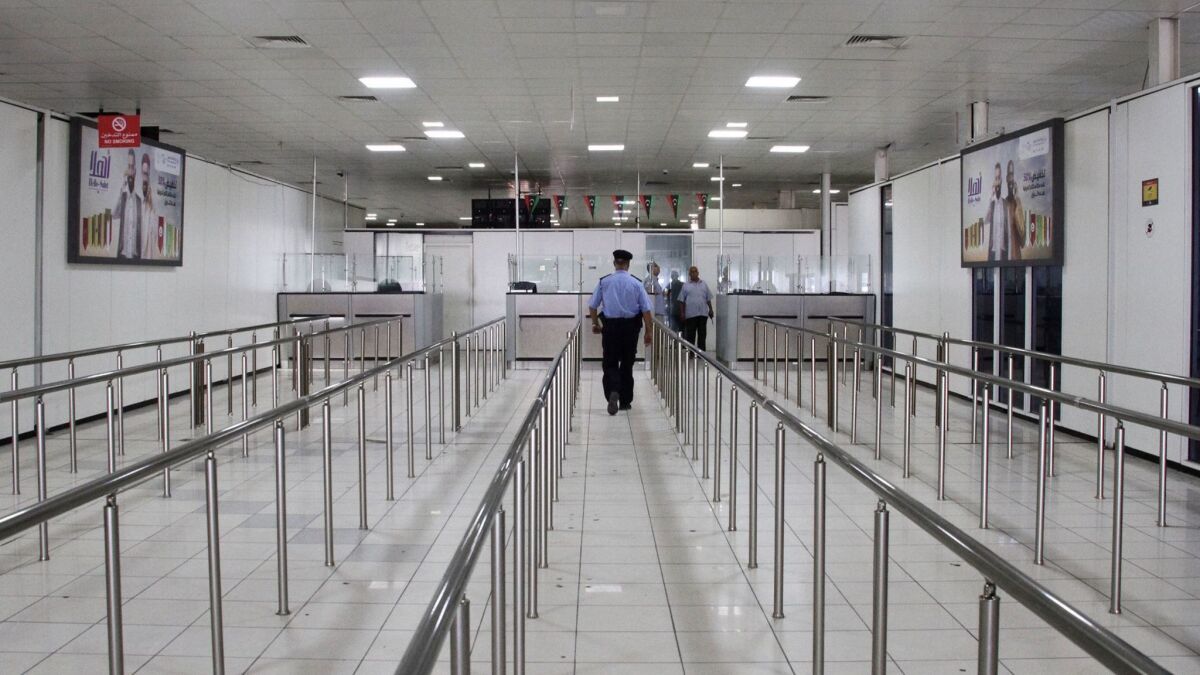 A Libyan police officer walks through the now-empty Mitiga International Airport on Tuesday in Tripoli.