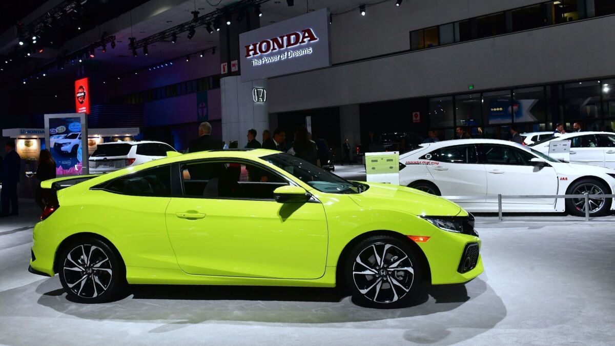 New Honda Civics, including a yellow Civic Si 2-door, on display at AutoMobility L.A., the trade show ahead of the L.A. Auto Show, on Nov. 28 at the Los Angeles Convention Center.