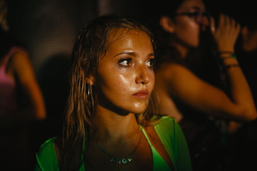 A woman looks alarmed on a dance floor.