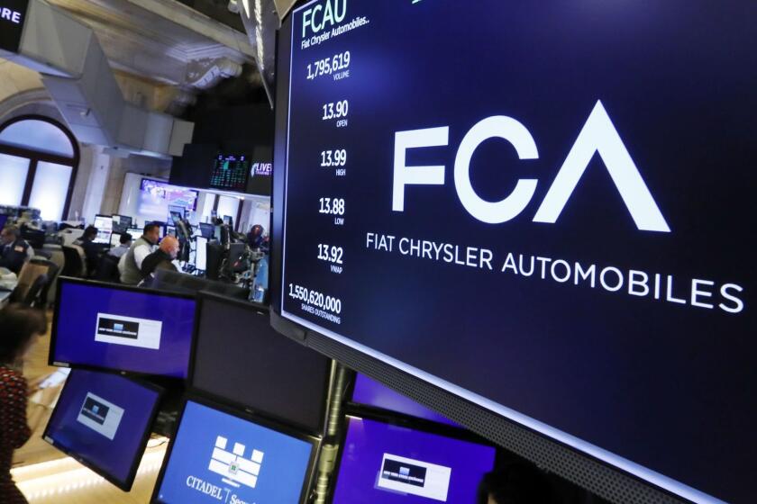 The Fiat Chrysler Automobiles logo appears above a post on the floor of the New York Stock Exchange, Tuesday, May 28, 2019. Fiat Chrysler is proposing a merger with French carmaker Renault aimed at saving billions of dollars for both companies. (AP Photo/Richard Drew)