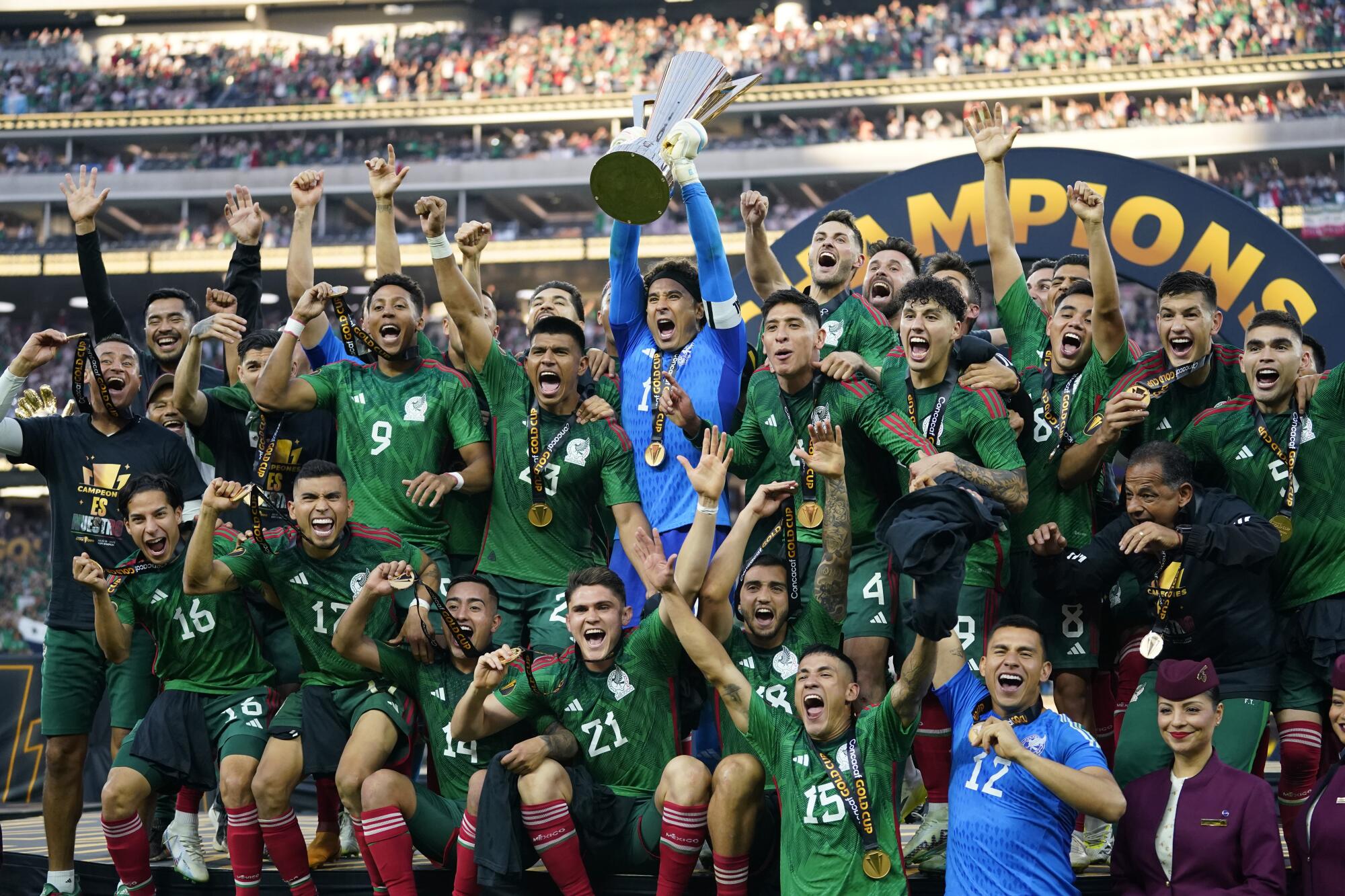 Mexico players celebrate with the winner's trophy.