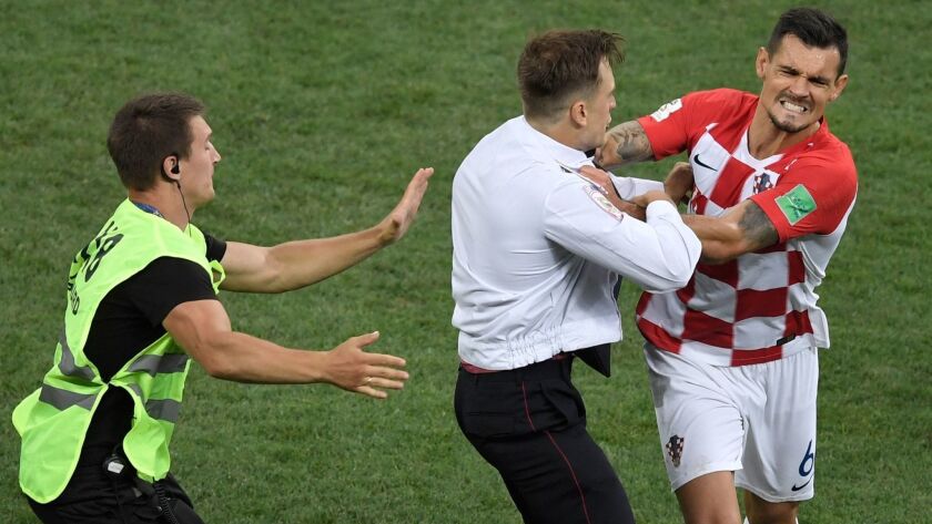 Croatia's defender Dejan Lovren (right) grabs a fan who went onto the pitch during the World Cup final with France.