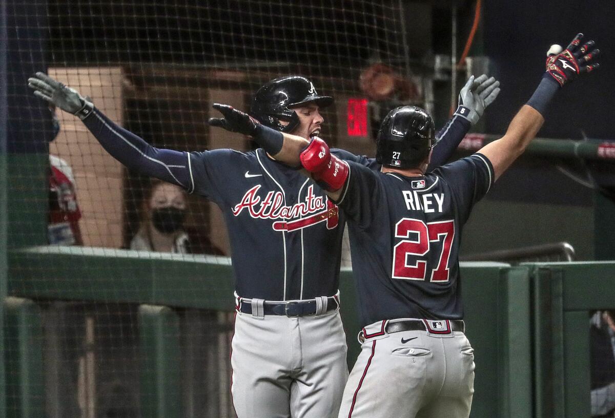 Freddie Freeman embraces Braves teammate Austin Riley who homered in the ninth inning in Game 1.