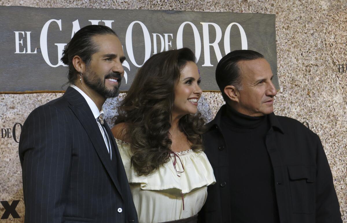 Los actores José Ron, izquierda, Lucero, centro, y Plutarco Haza posan en la alfombra roja de la serie de ViX "El gallo de oro" en la Ciudad de México el martes 17 de octubre de 2023.