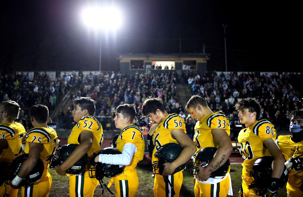 Members of the Paradise High School football team stand for the national anthem before a game against Willows on Friday.