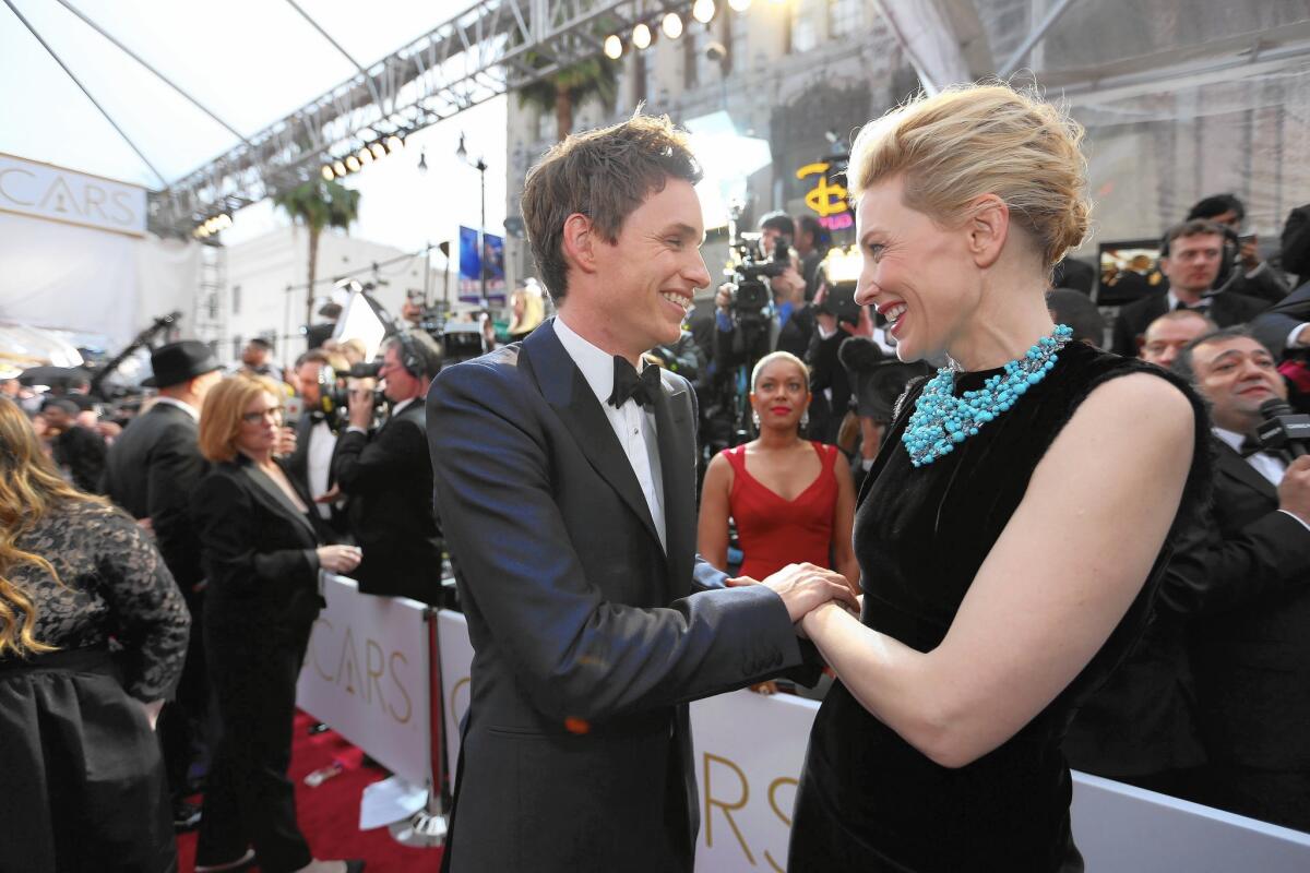 A moment foretold. Eddie Redmayne and Cate Blanchett embrace on the red carpet. Hours later, Blanchett, last year’s lead actress recipient, would hand the exuberant Redmayne his lead actor Oscar for portraying Stephen Hawking in “The Theory of Everything.”