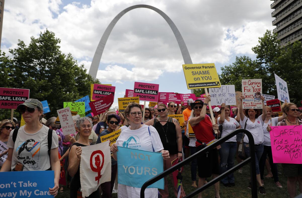 Protesters march in 2019 with the Gateway Arch in background 