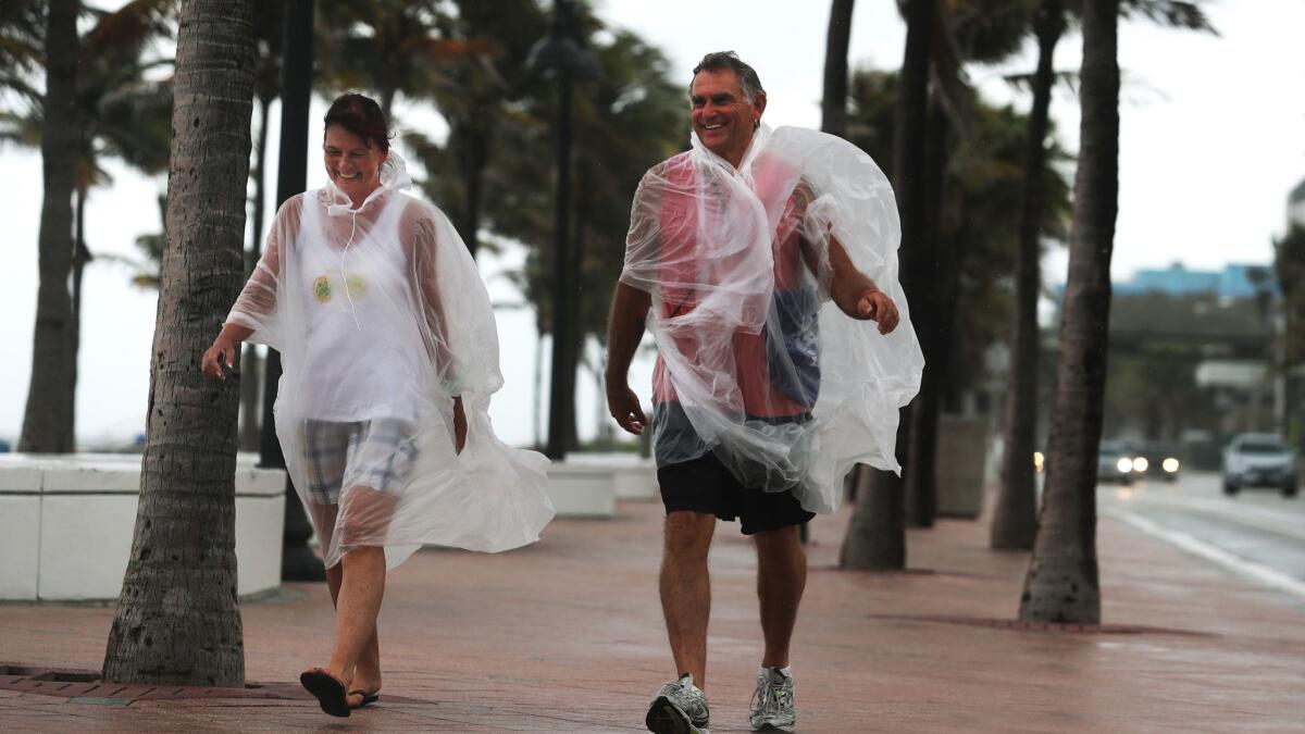 Andrea Minz and Hans Jonen, tourists from Germany, walk near the beach in Fort Lauderdale, Fla.