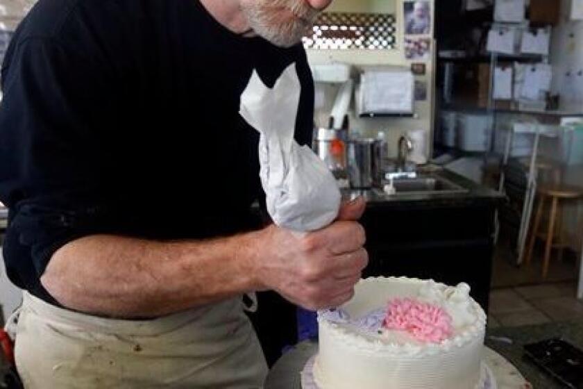 File - In this March 10, 2014 file photo, Masterpiece Cakeshop owner Jack Phillips decorates a cake inside his store, in Lakewood, Colo. Colorado's Civil Rights Commission on Friday upheld a judge's ruling that Phillips cannot refuse to make wedding cakes for same-sex couples, despite Phillips' cited religious opposition to same sex marriage. The panel says doing so violates state laws prohibiting businesses from discriminating against gay people. (AP Photo/Brennan Linsley, file)