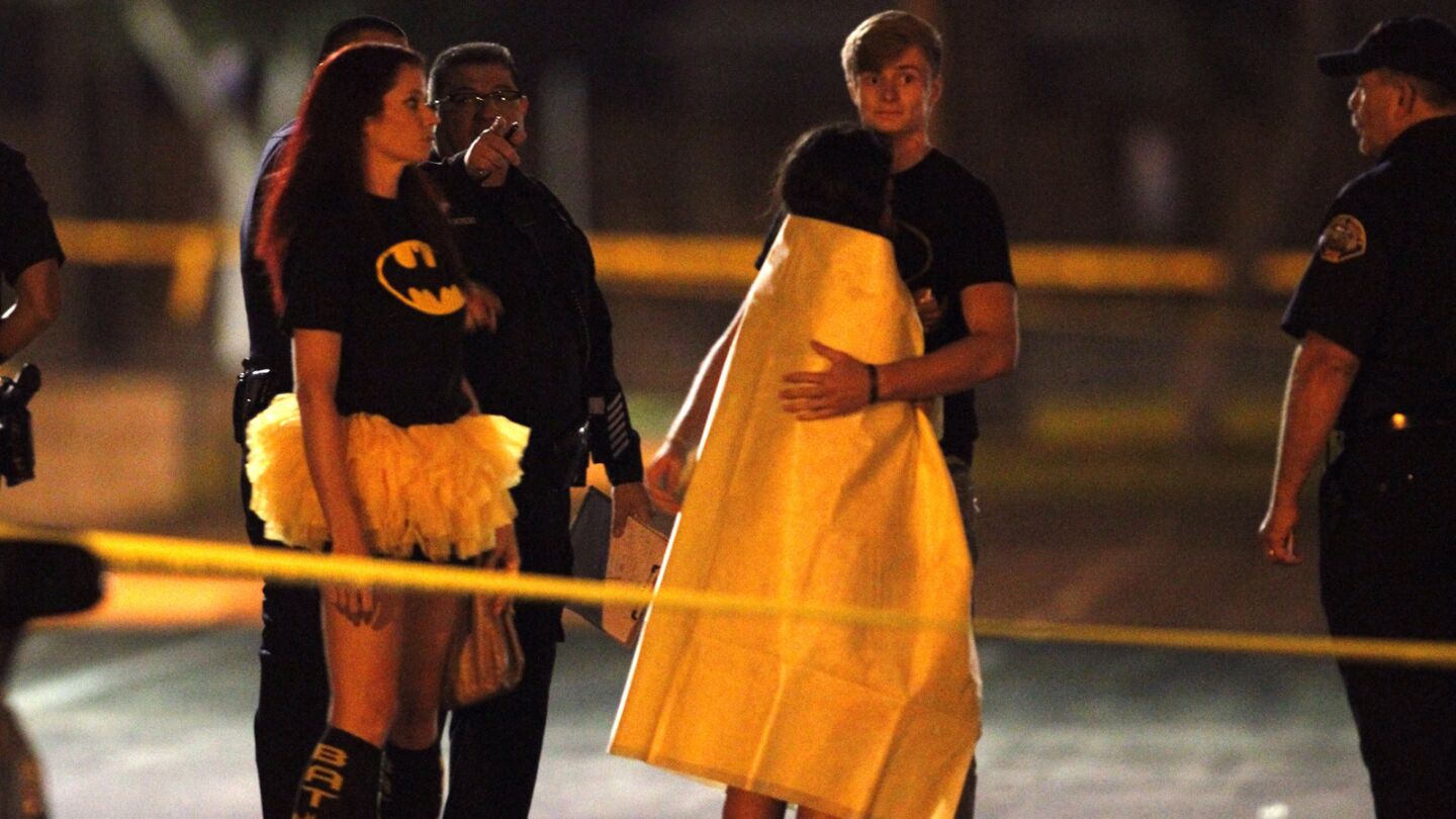 Friends comfort each other after three teenage trick-or-treaters were killed in Santa Ana on Friday.