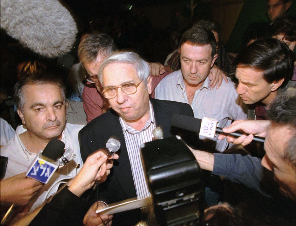 FILE - In this Nov. 4, 1995, file, photo, Eitan Haber, center, announces outside the death of Israeli Prime Minister Yitzhak Rabin, who was gunned down by a Jewish extremist following a rally in Tel Aviv. Haber, a former journalist and adviser to Rabin, died on Wednesday, Oct. 7, 2020. He was 80. (AP Photo/Eyal Warshavsky, File)
