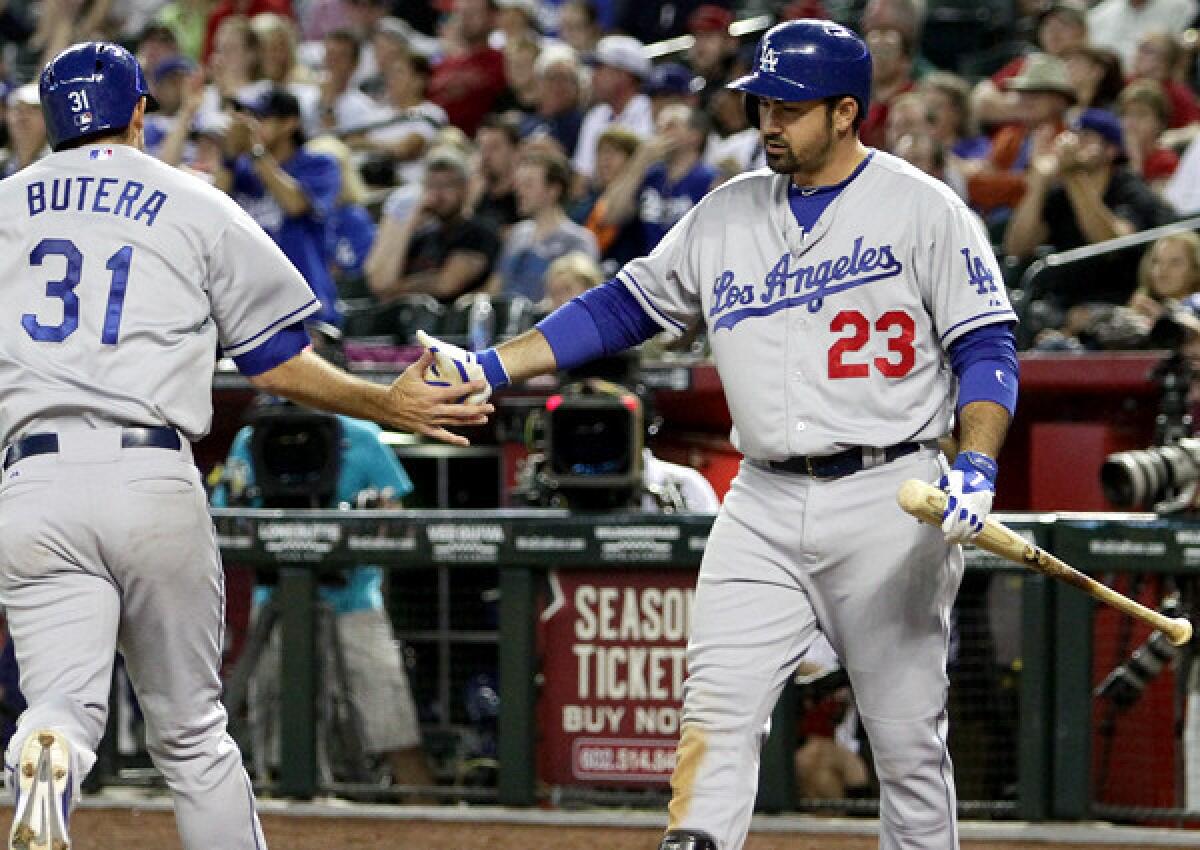 Dodgers first baseman Adrian Gonzalez celebrates with catcher Drew Butera, who scored in the sixth inning against the Diamondbacks on Saturday night in Phoenix.