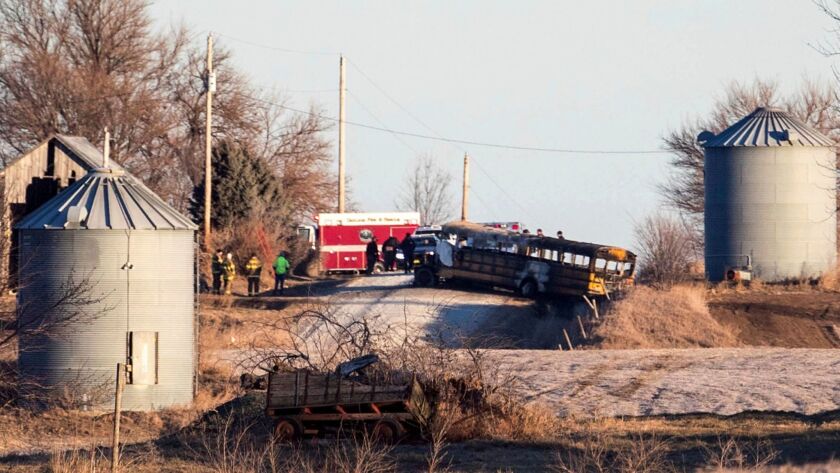 Investigators work the scene of a school bus fire that killed at least two near Oakland, Iowa.