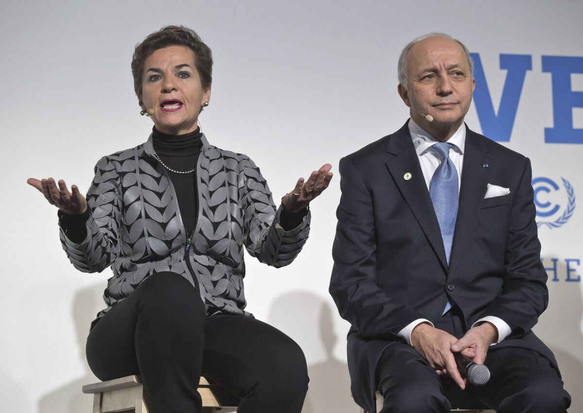 U.N. climate chief Christiana Figueres speaks on Action Day as French Foreign Minister Laurent Fabius listens at the climate conference outside Paris.