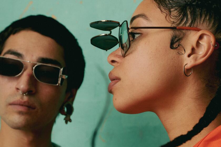 Gabrielle Ebron and Xochi Chimalli pose in front of a teal backdrop wearing l.a.Eyeworks sunglasses