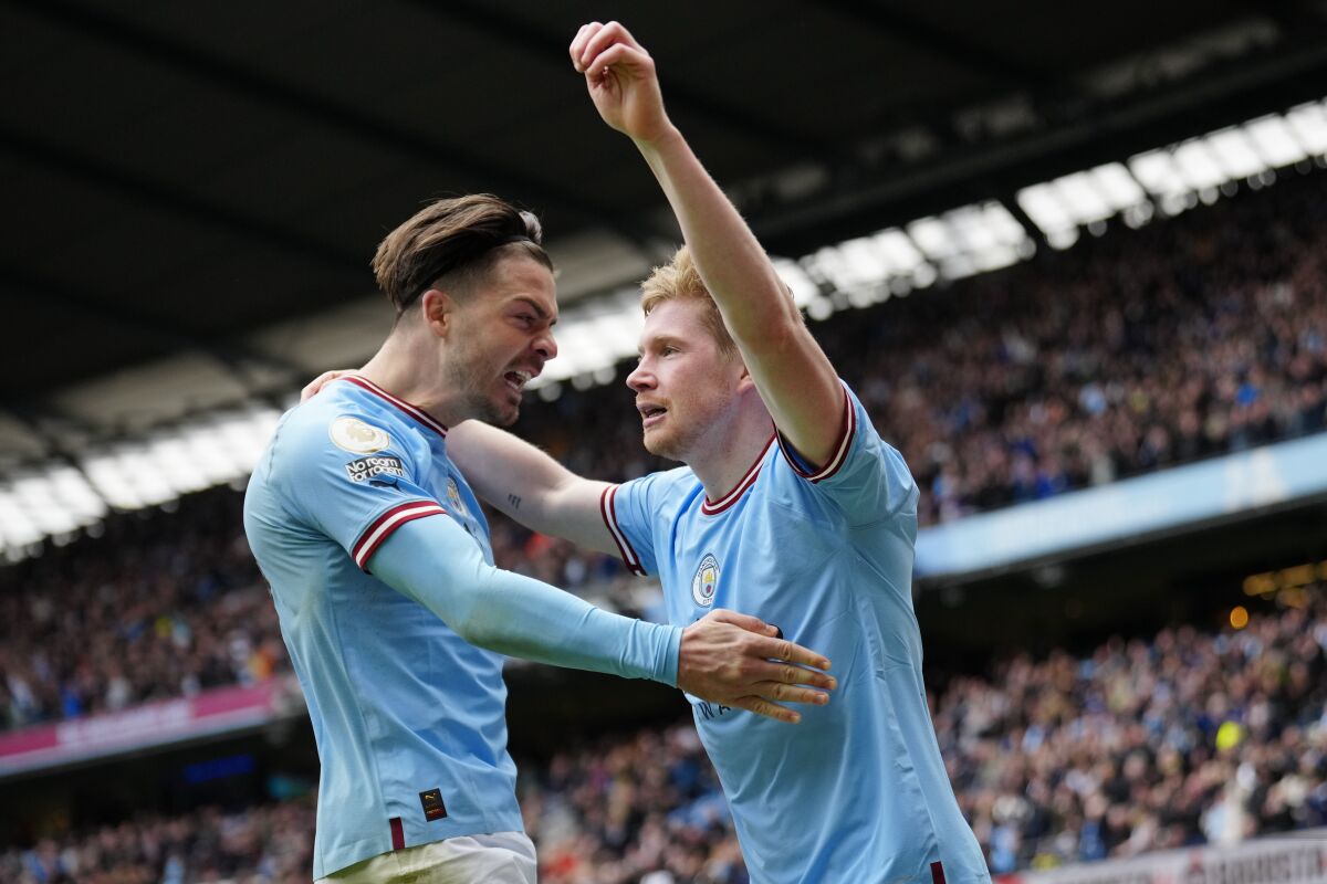 Manchester City's Kevin De Bruyne, right, celebrates with teammate Jack Grealish after scoring his his side's 2nd goal during the English Premier League soccer match between Manchester City and Liverpool at Etihad stadium in Manchester, England, Saturday, April 1, 2023. (AP Photo/Jon Super)