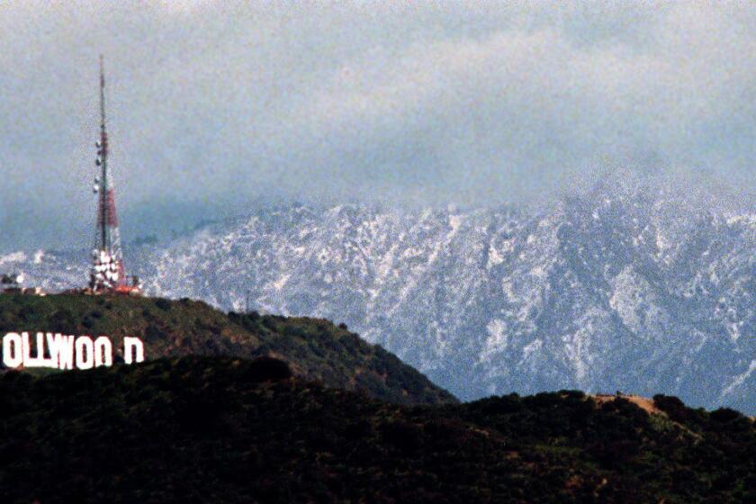 Snow forms a backdrop to the Hollywood sign after an El Niño storm in 1998.