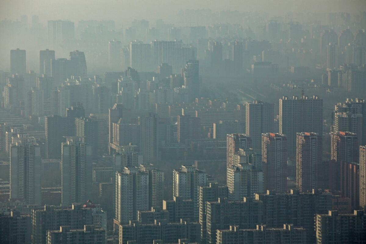 Smog fills the air above housing block towers in Bejing, China.