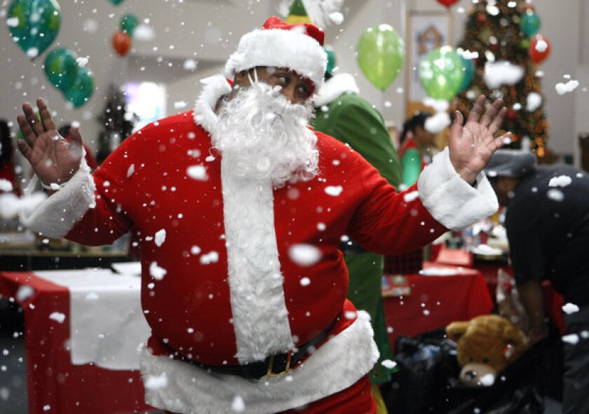 Don Perkins, a resident at the Union Rescue Mission in downtown Los Angeles, dresses up as Santa Claus during its 22nd annual Christmas Store for needy families.