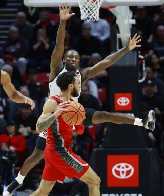 San Diego State's Darrion Trammell guards New Mexico's Jaelen House.