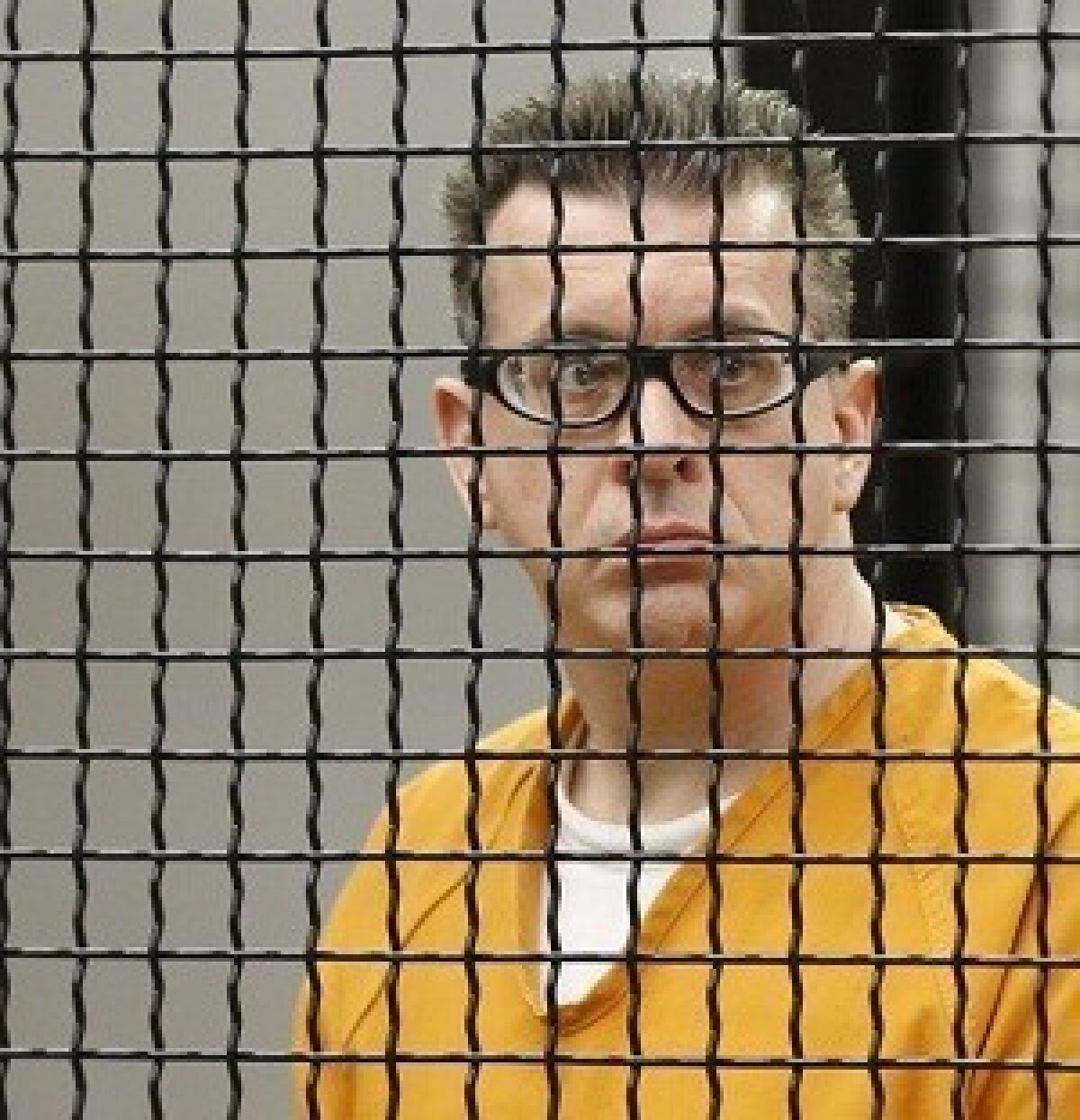 Former UC Irvine professor Rainer Klaus Reinscheid looks out from the prisoner's cage during his arraignment.