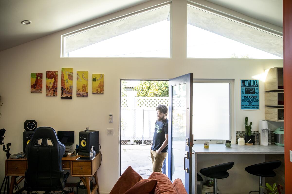 A man stands in an open doorway.