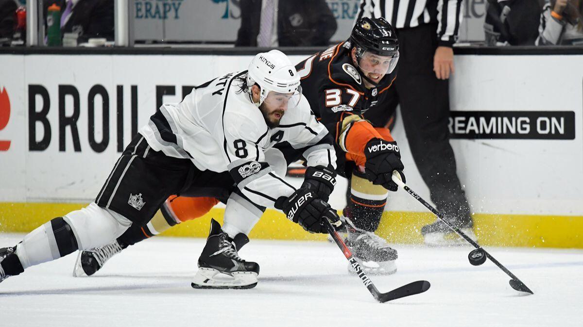 Kings defenseman Drew Doughty, left, and Anaheim Ducks left wing Nick Ritchie reach for the puck during the second period on Tuesday at the Honda Center.