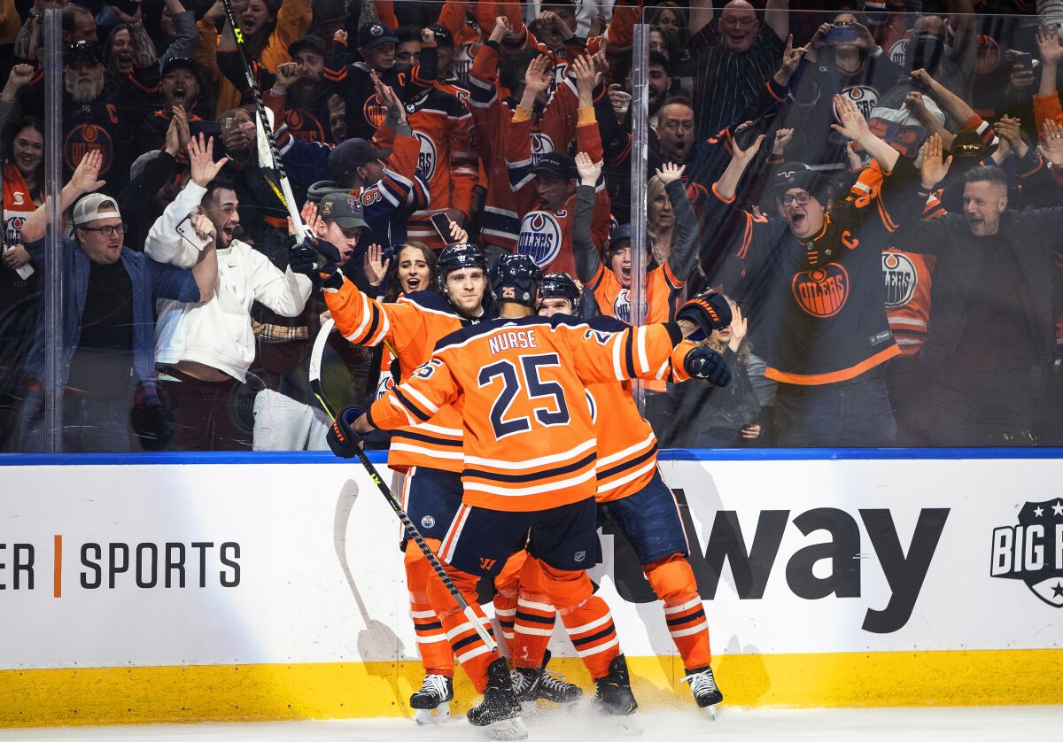 Edmonton Oilers' Leon Draisaitl (29), Connor McDavid (97) and Darnell Nurse (25) celebrate the team's overtime win against the St. Louis Blues during an NHL hockey game Friday, April 1, 2022, in Edmonton, Alberta. (Jason Franson/The Canadian Press via AP)