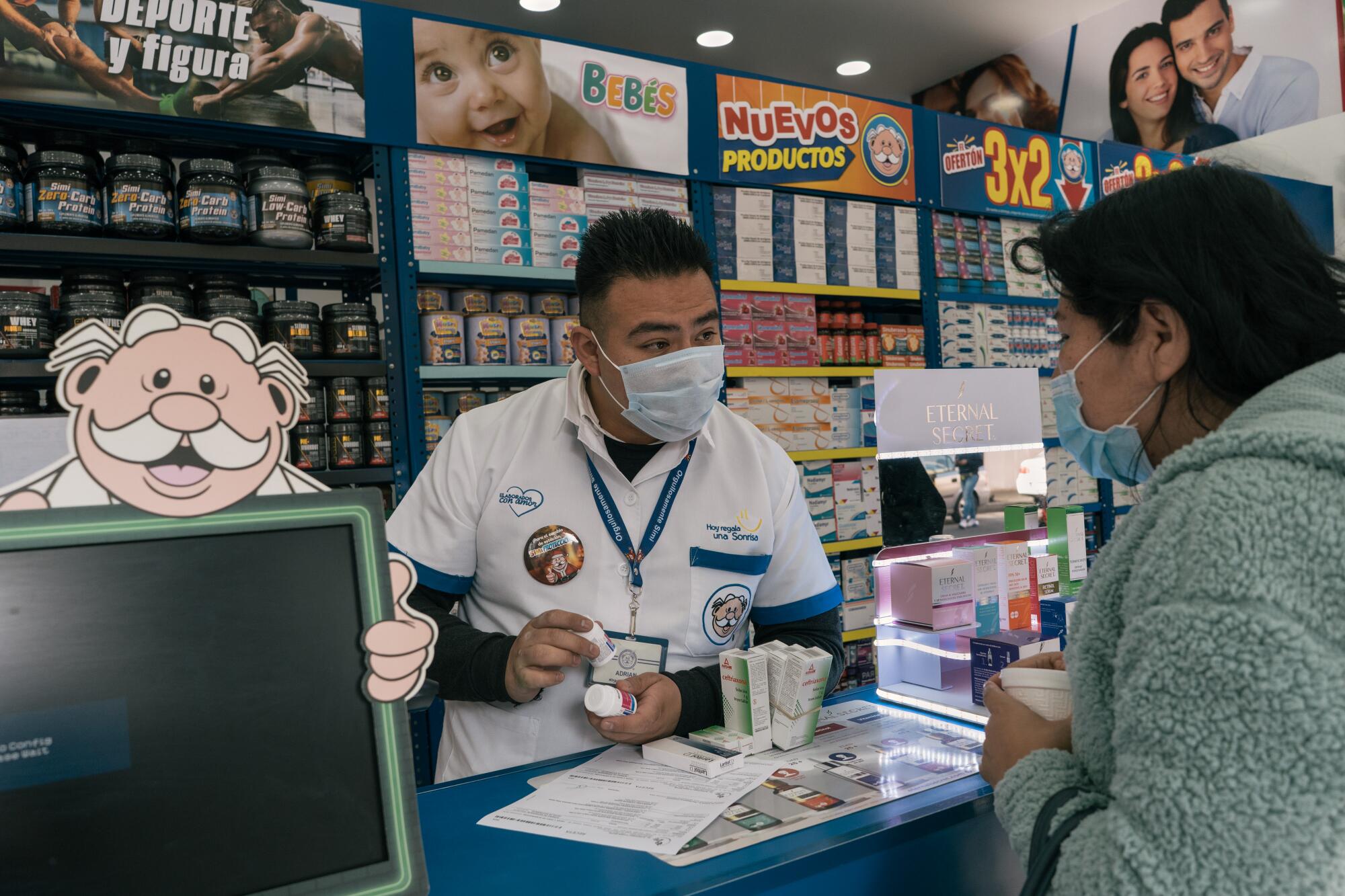 A masked man in white uniform behind a counter speaks to a woman near a cartoon display of man with white hair and mustache