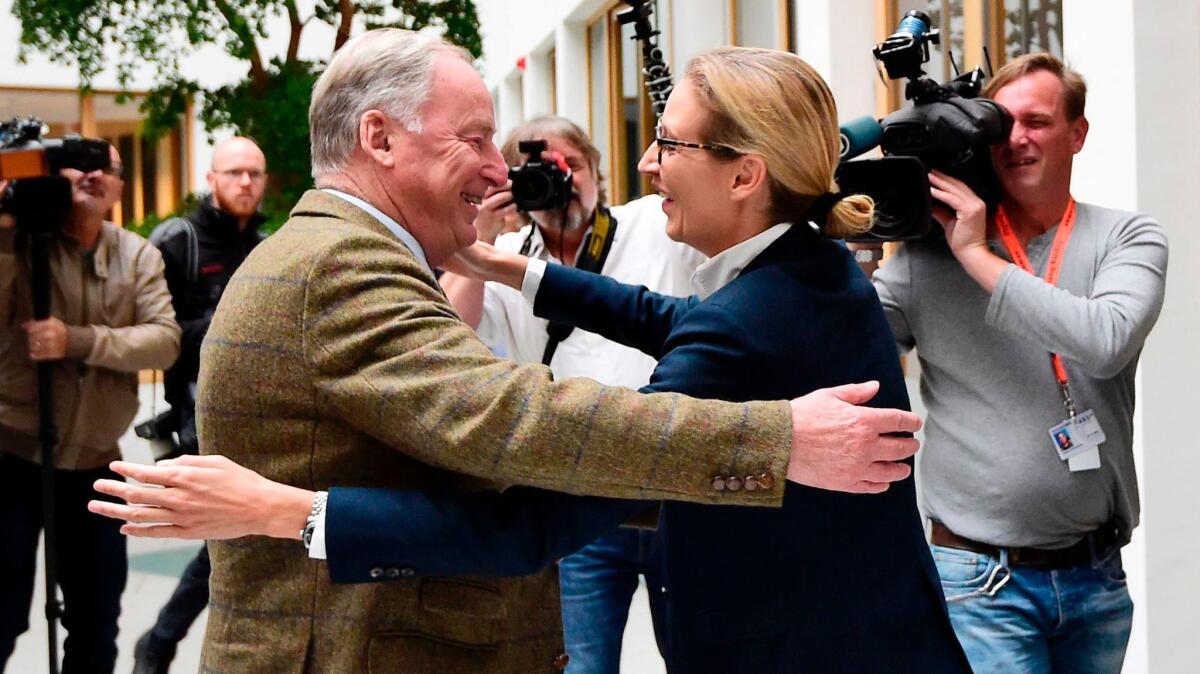 The leading candidates of the far-right Alternative for Germany party, Alexander Gauland and Alice Weidel, hug before addressing a news conference on Sept. 25, 2017, in Berlin.