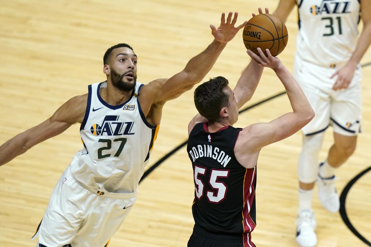 Utah Jazz center Rudy Gobert, left, tries to block a shot by Miami Heat guard Duncan Robinson during a game on Feb. 26.