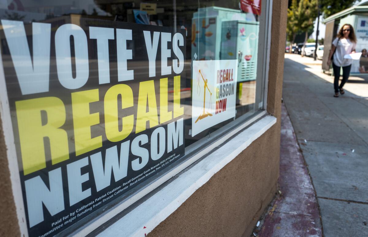 A sign urging people to vote yes on recalling Gov. Gavin Newsom sits in a storefront window in Burbank on Aug. 25. 