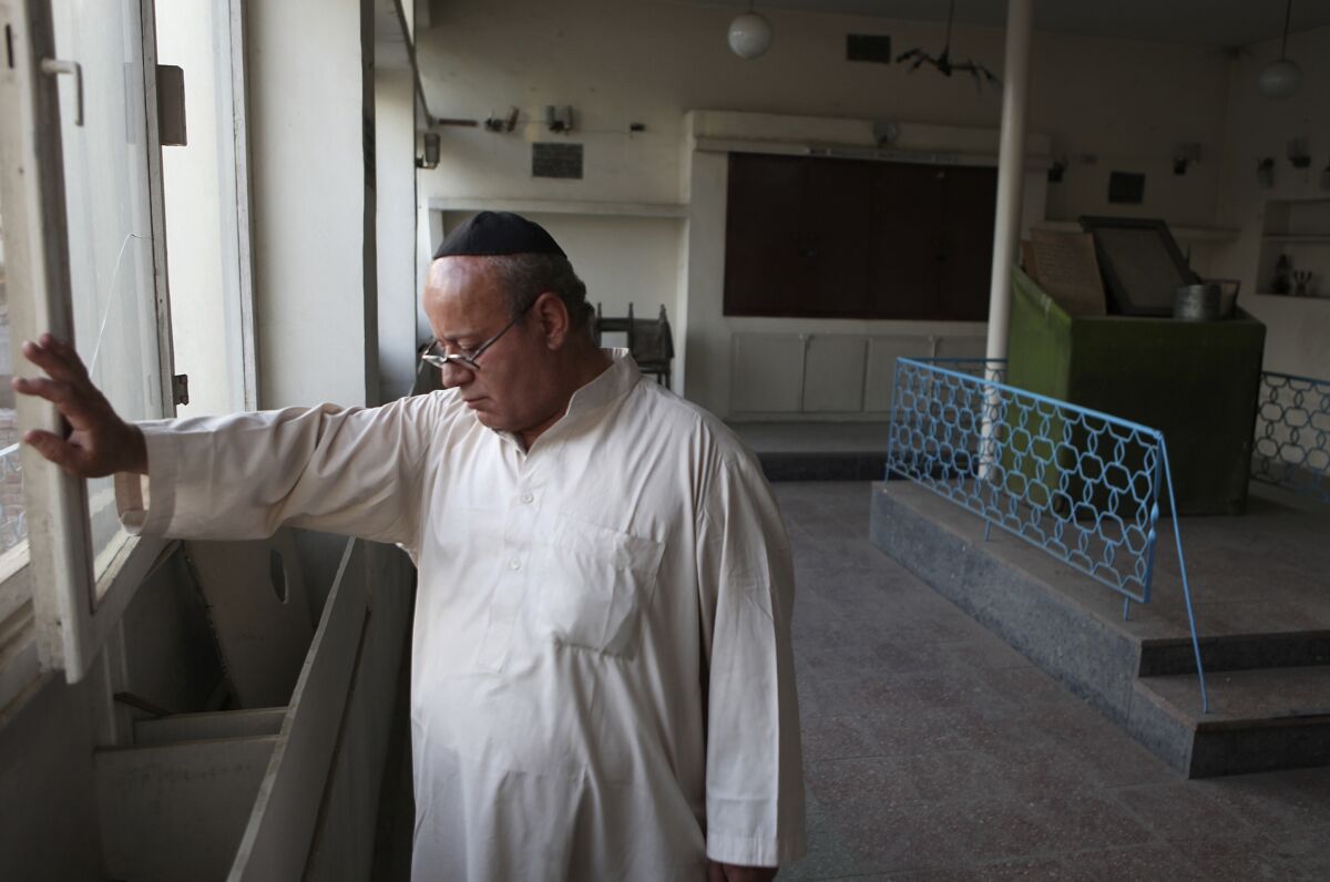 FILE - In this Aug. 29, 2009 file photo, Zebulon Simentov, the last known Jew living in Afghanistan, closes the window to the synagogue he cares for in his Kabul home. Simentov who prayed in Hebrew, endured decades of war as the country's centuries-old Jewish community rapidly dwindled has left the country. The Taliban takeover in August, 2021, seems to have been the last straw. (AP Photo/David Goldman, File)