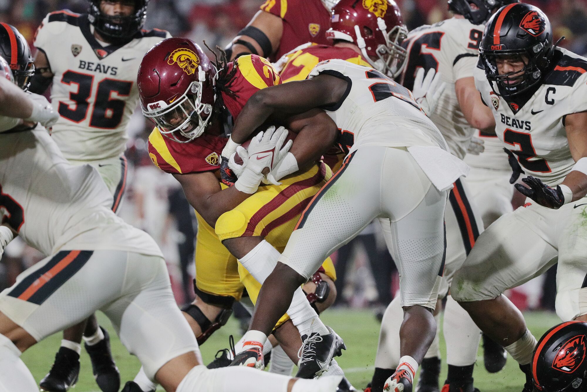 Oregon State defensive back Kitan Oladapo tries to strip the ball from USC running back Keaontay Ingram.