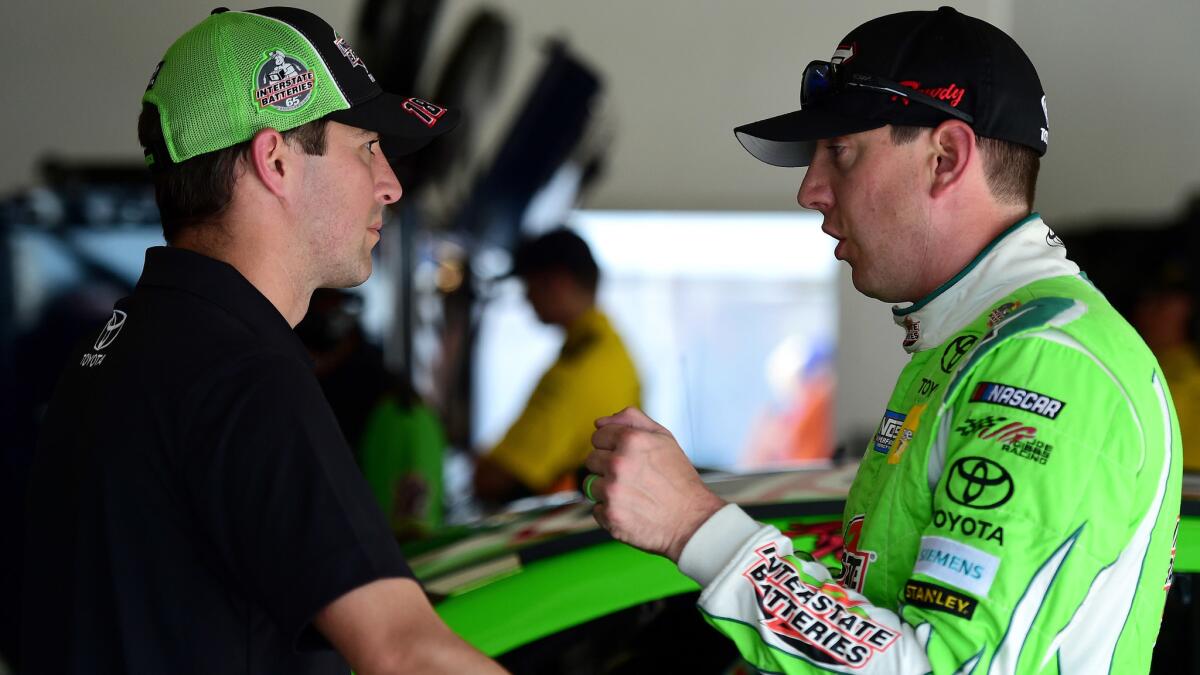 NASCAR driver Kyle Busch talks with his interim crew chief Jacob Canter in the garage area during practice for the Monster Energy NASCAR Cup Series Coke Zero on Thursday.