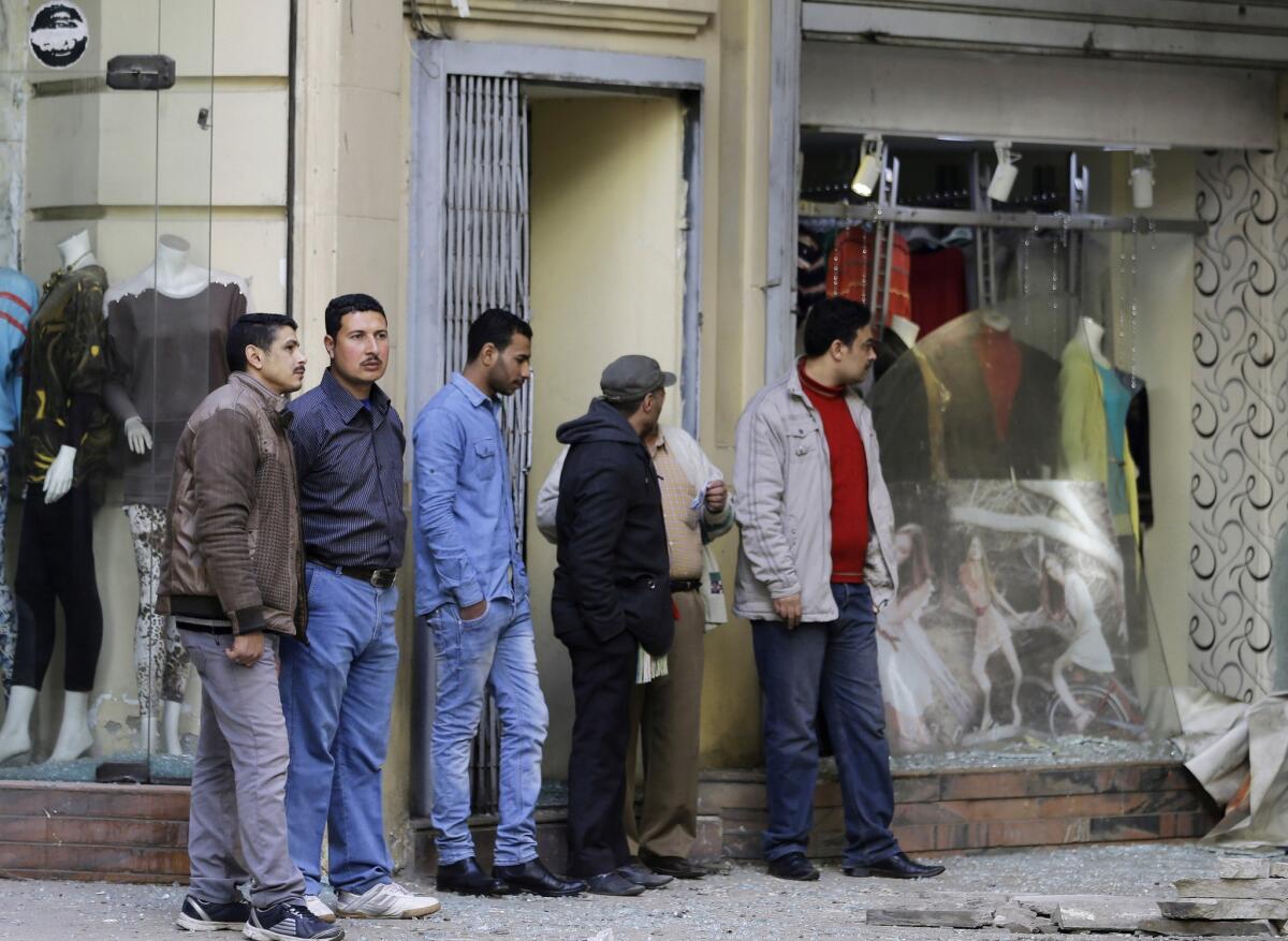 Passersby inspect the damage after a flash-bang grenade exploded in downtown Cairo on Feb. 3.