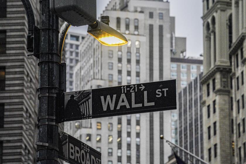 A street light brightens a Wall Street sign outside the New York Stock Exchange, Monday, Oct. 3, 2022, in New York. Stocks are off to a mostly higher start on Wall Street, Tuesday, Oct. 25, as traders take in a big round of earnings reports from big U.S. companies. (AP Photo/Bebeto Matthews, File)