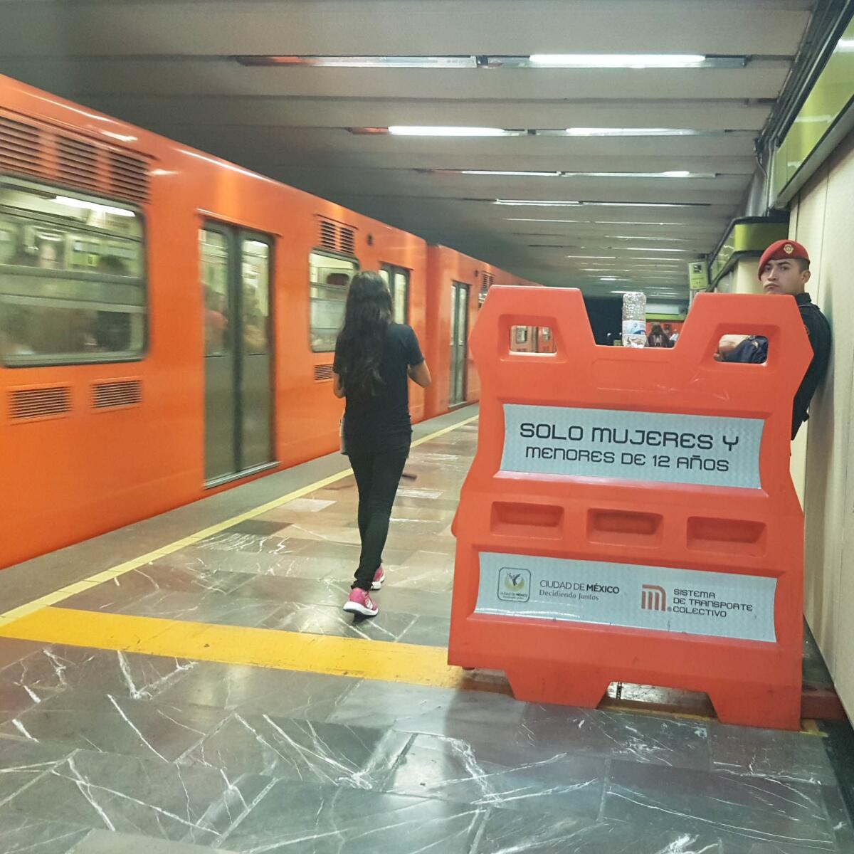 A woman walks toward the area designated for women and children only in a Mexico City subway station.