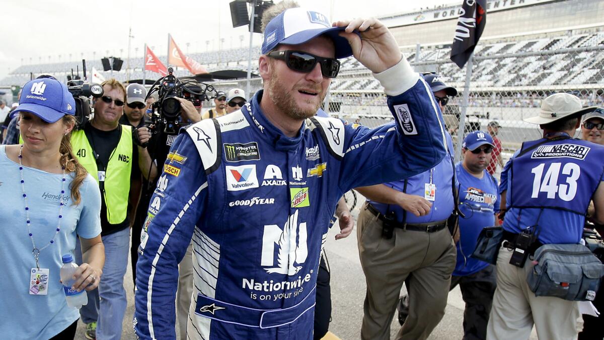 NASCAR driver Dale Earnhardt Jr. walks back to the garage area after winning the pole position during qualifying Friday for the Coke Zero 400 at Daytona International Speedway.