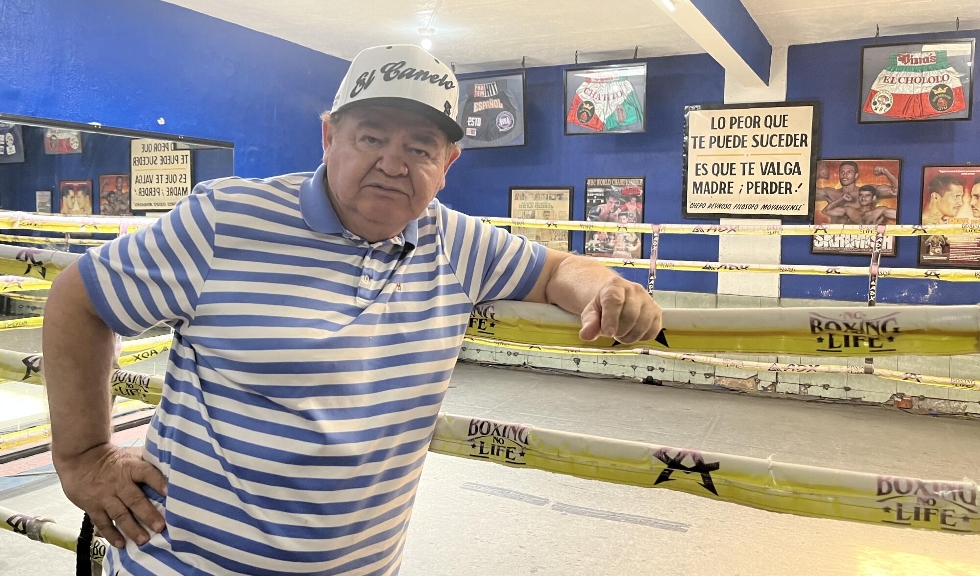 Don Chepo Reynoso y su famoso letrero en el gimnasio.